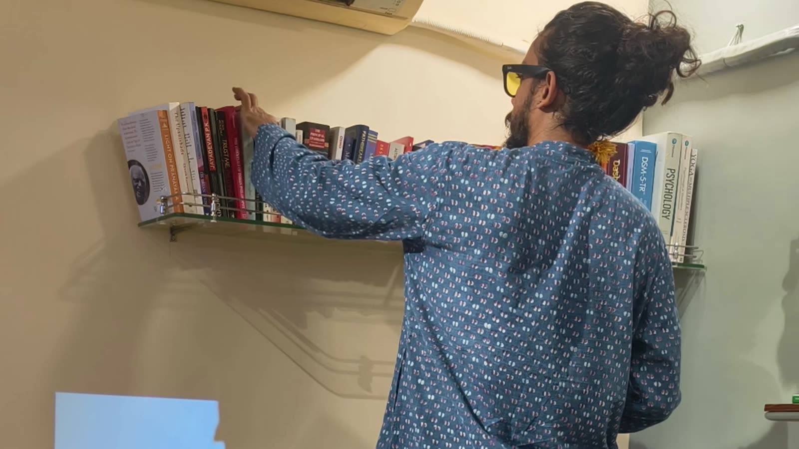 Aditya reaching for a book on the Sylvaris shelf.